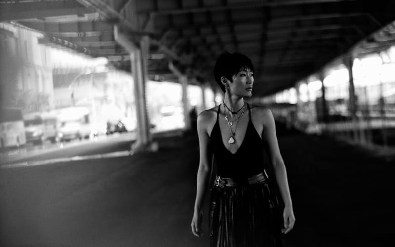 Black and white image set under bridge features Jihae in foreground