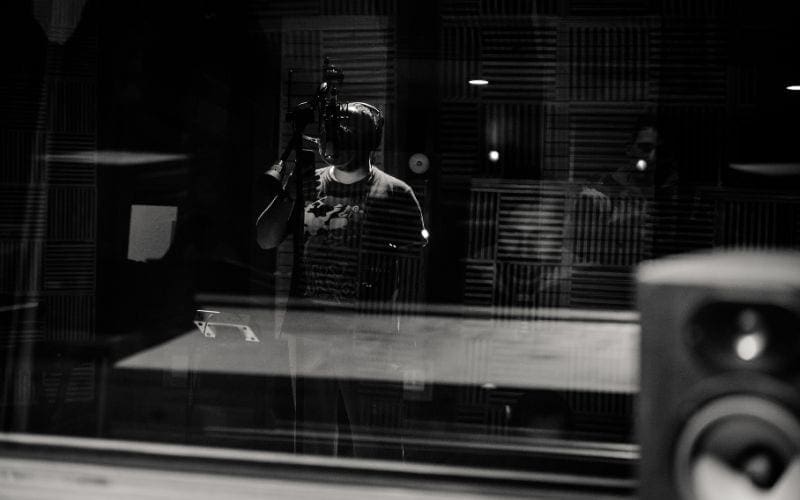 man singing in recording studio making beats