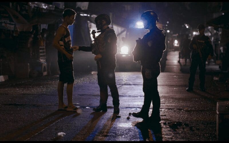 Two armed police talking to a citizen.