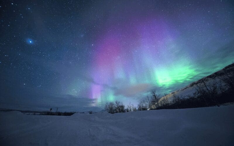 The aurora borealis with a snowy enviroment.
