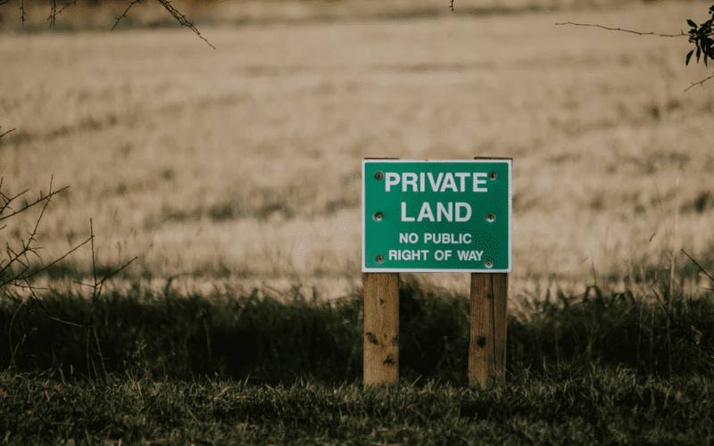 Private land sign in front of a field.