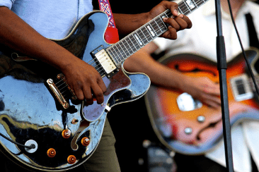 two people playing electric guitars