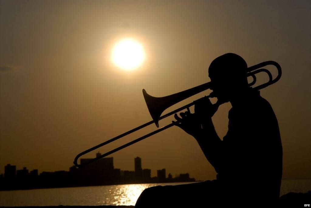 Man playing trombone at sunset
