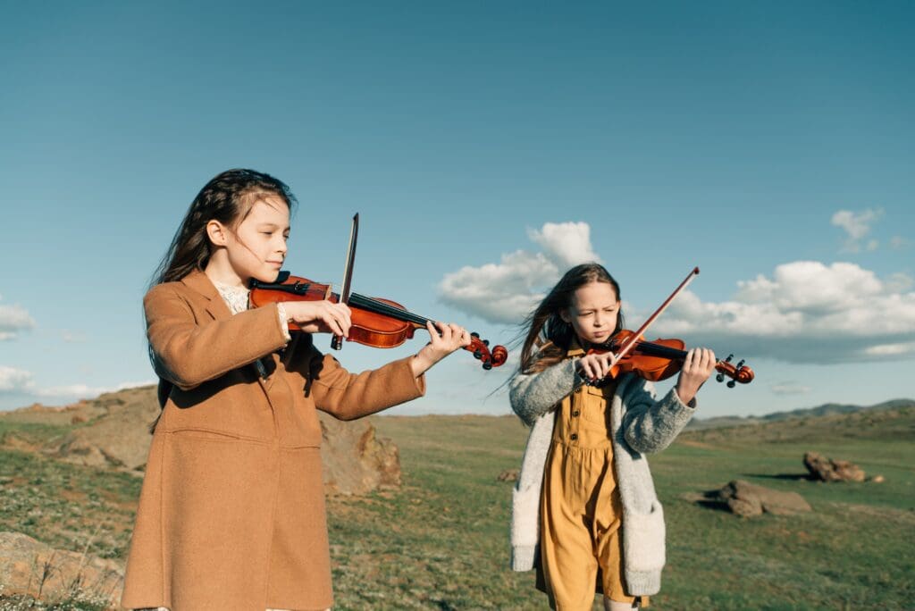 Two young girls play the violin