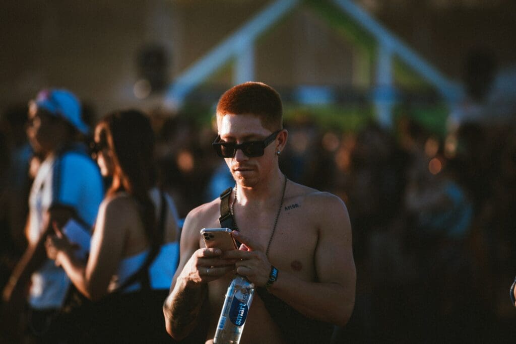Man in crowd at festival looking at phone